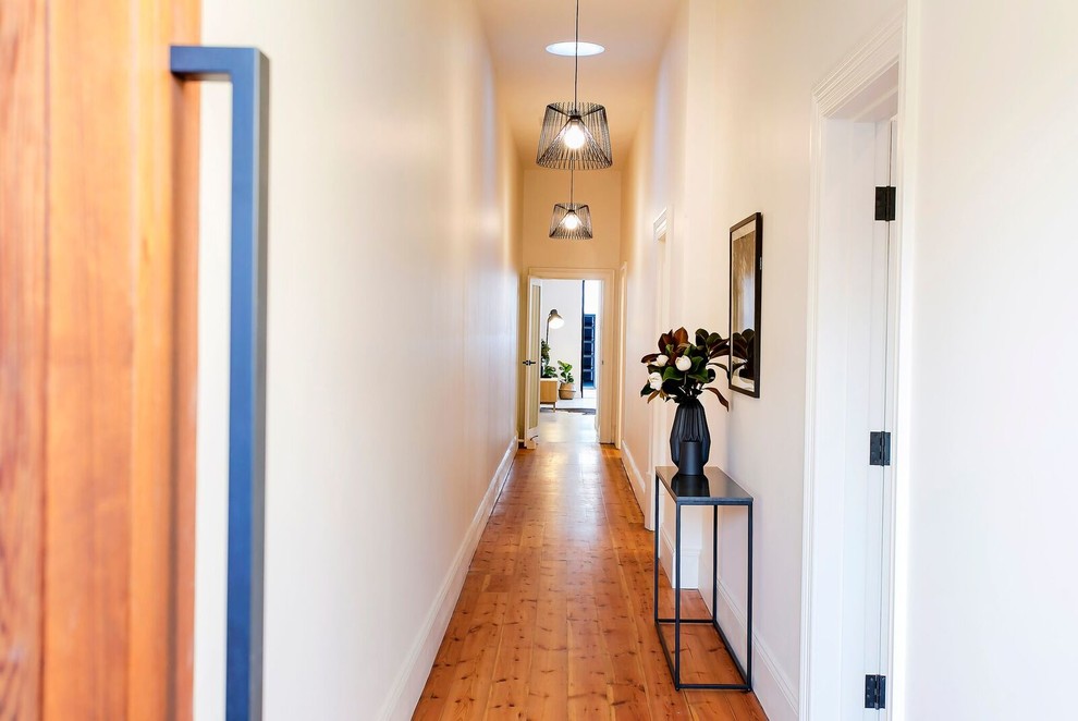 Kleiner Moderner Flur mit weißer Wandfarbe und braunem Holzboden in Adelaide