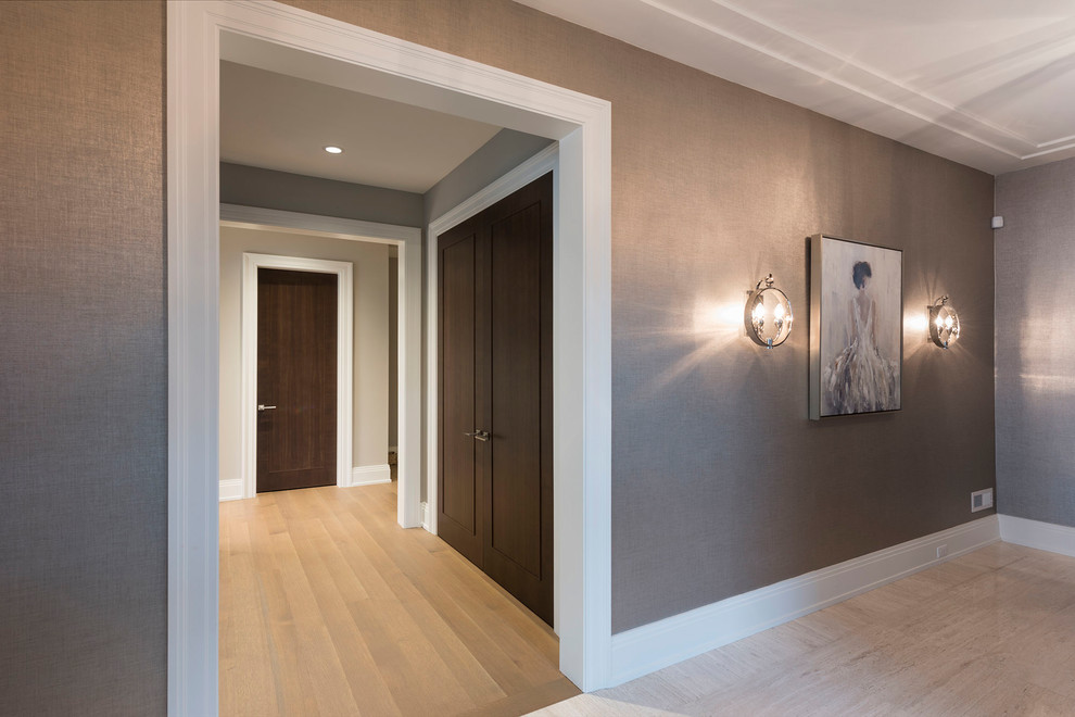 Exemple d'un couloir tendance de taille moyenne avec un mur gris, parquet clair et un sol beige.
