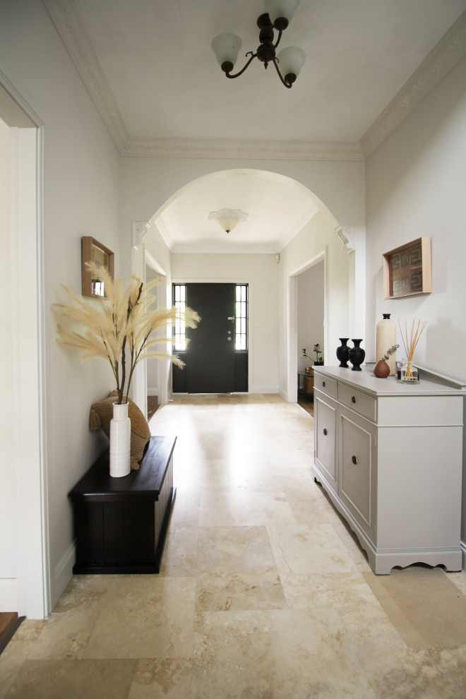 Idée de décoration pour un couloir tradition de taille moyenne avec un sol en travertin, un sol beige et un mur blanc.