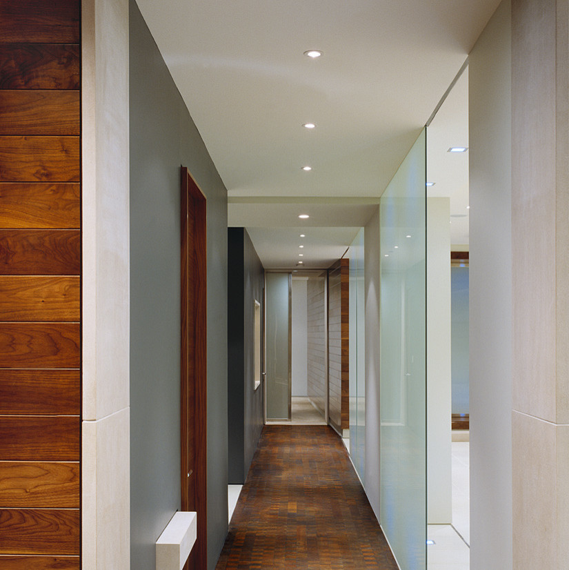 Exemple d'un couloir moderne avec parquet foncé et un mur gris.