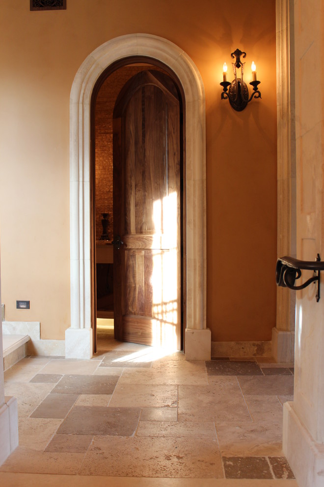 На фото: коридор среднего размера в средиземноморском стиле с бежевыми стенами, полом из травертина и бежевым полом