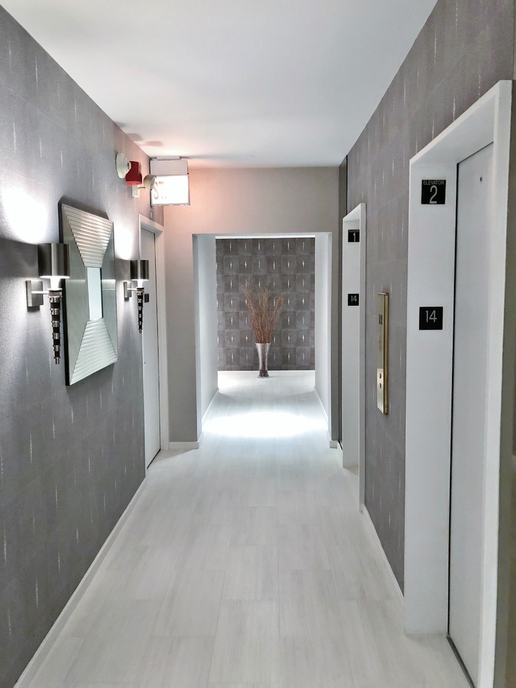 На фото: большой коридор в стиле модернизм с коричневыми стенами, полом из керамогранита и белым полом с