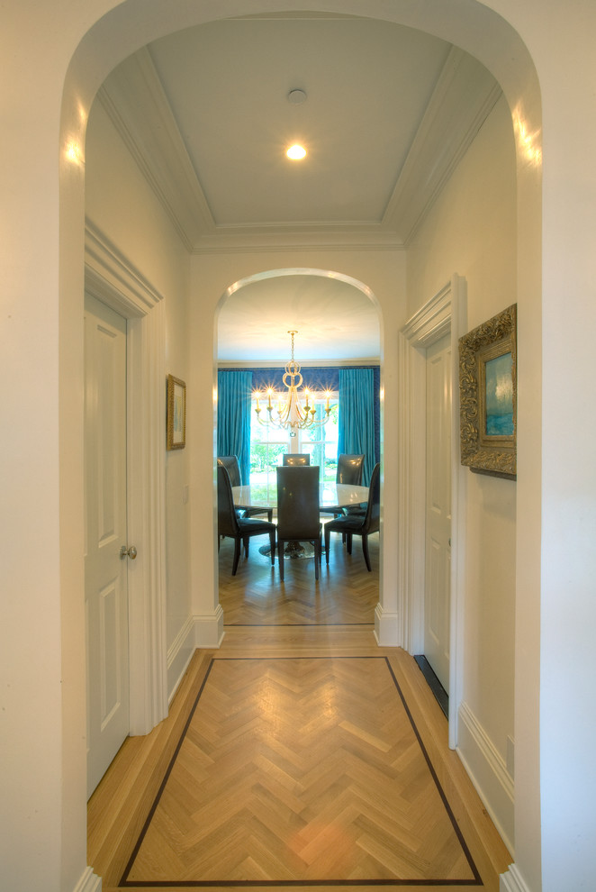 Ispirazione per un ingresso o corridoio tradizionale di medie dimensioni con pareti bianche e parquet chiaro
