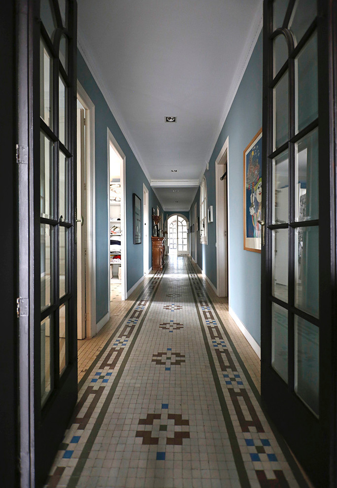 Foto de recibidores y pasillos eclécticos grandes con paredes azules y suelo de baldosas de cerámica