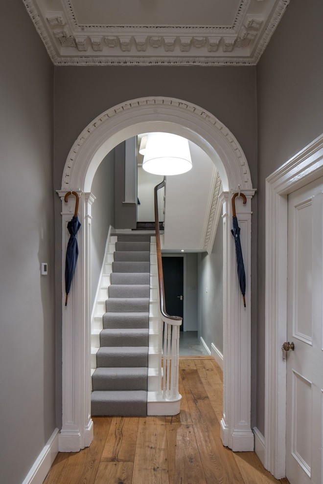Ispirazione per un ingresso o corridoio vittoriano con pareti grigie e pavimento in legno massello medio