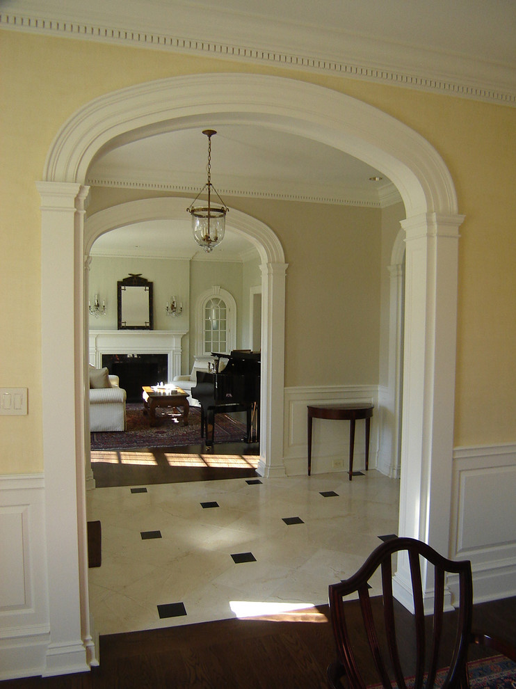 На фото: коридор в классическом стиле с желтыми стенами и мраморным полом