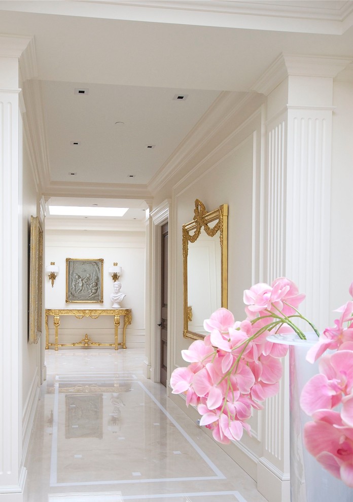 Пример оригинального дизайна: огромный коридор в классическом стиле с белыми стенами и мраморным полом