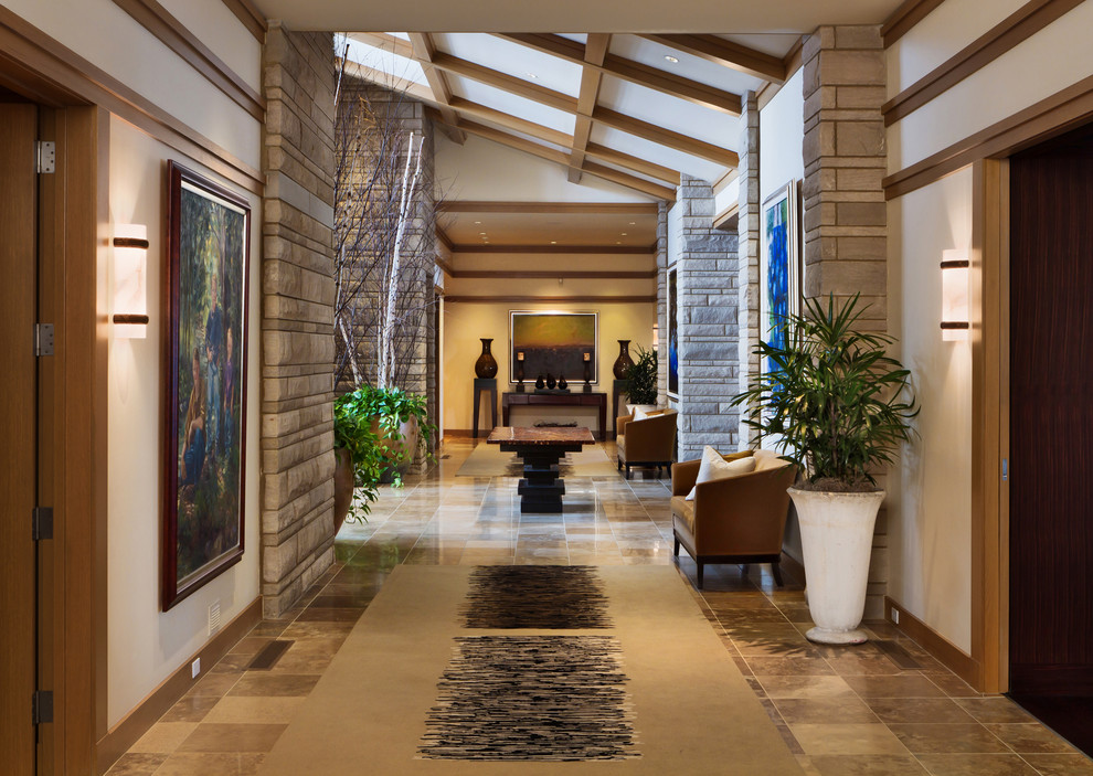 Immagine di un ampio ingresso o corridoio classico con pareti bianche, pavimento in travertino e pavimento marrone