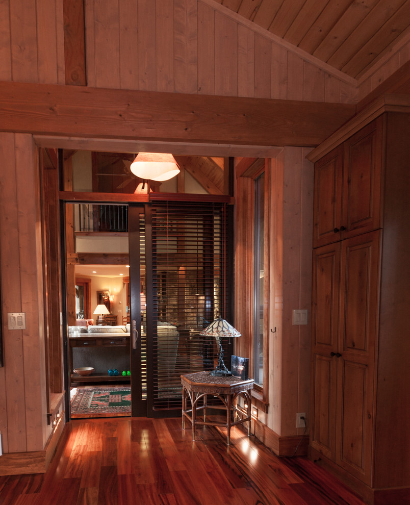 Hallway - small craftsman dark wood floor hallway idea in Other with brown walls