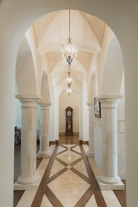 Cette image montre un grand couloir traditionnel avec un mur blanc et parquet foncé.