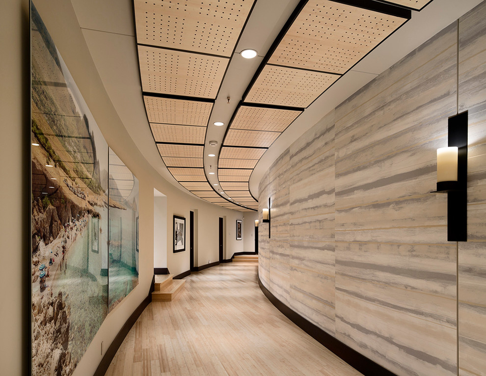 Réalisation d'un grand couloir design avec parquet clair et un mur beige.