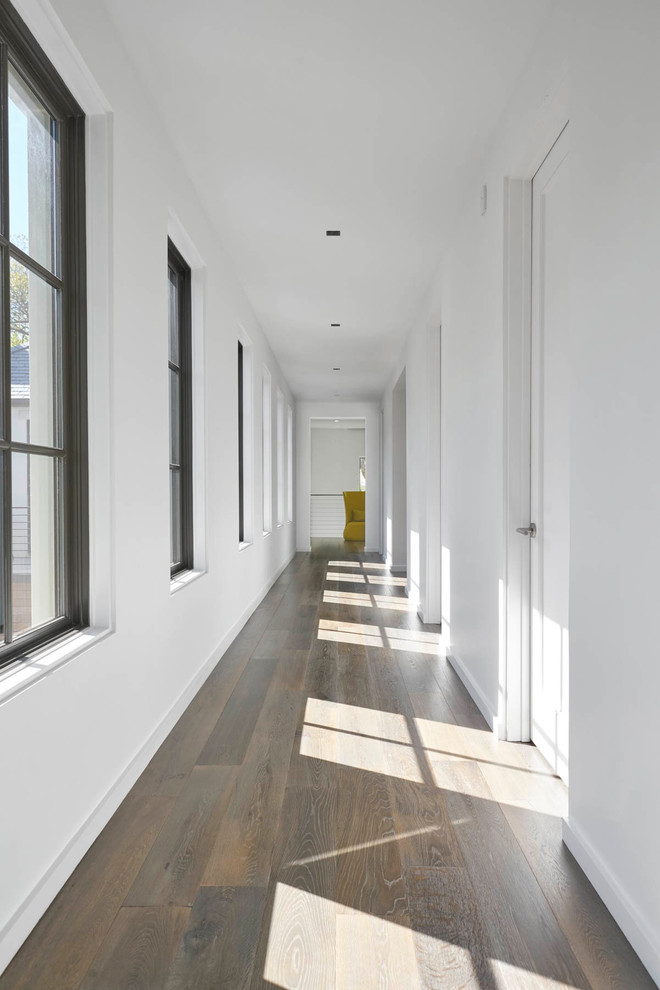 Идея дизайна: узкий коридор среднего размера в современном стиле с белыми стенами и темным паркетным полом