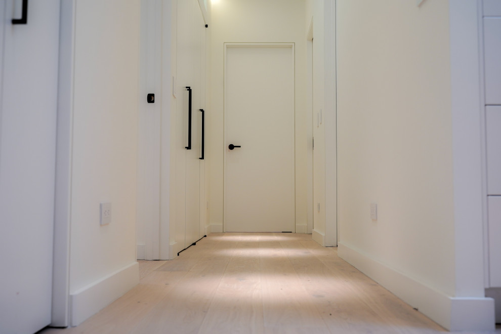 Idee per un ingresso o corridoio contemporaneo di medie dimensioni con pareti bianche, parquet chiaro e pavimento marrone