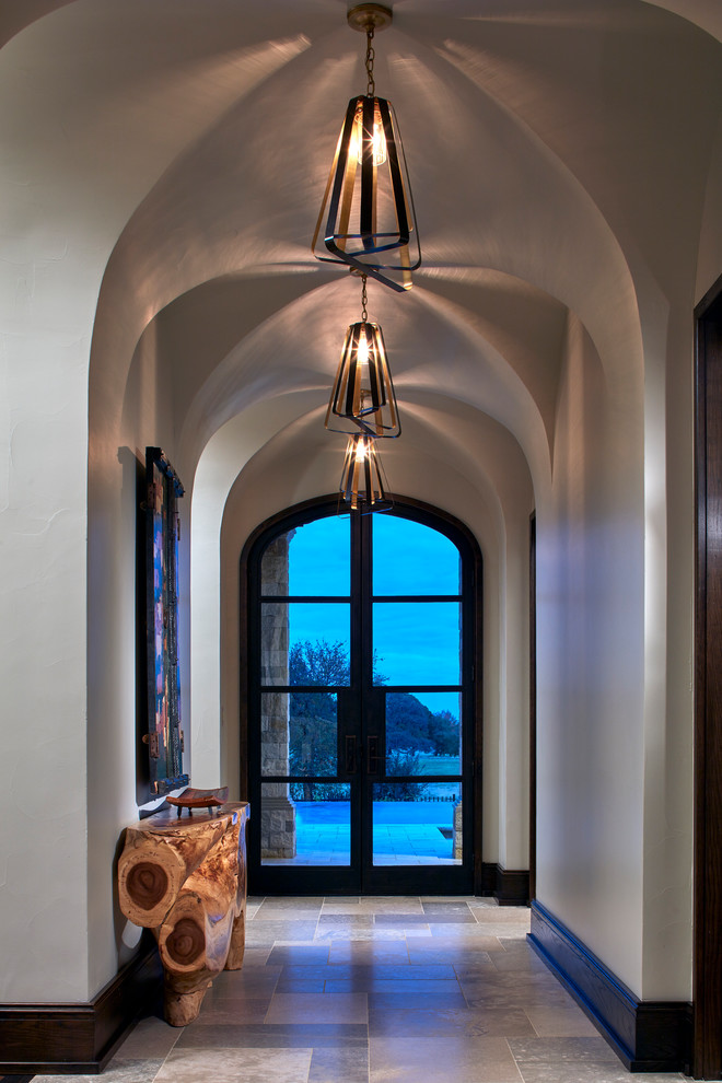 ダラスにあるラグジュアリーな広いトランジショナルスタイルのおしゃれな廊下 (ライムストーンの床、グレーの床、グレーの壁) の写真