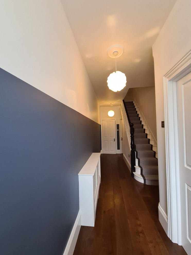 На фото: коридор среднего размера в стиле модернизм с синими стенами, темным паркетным полом, коричневым полом и многоуровневым потолком