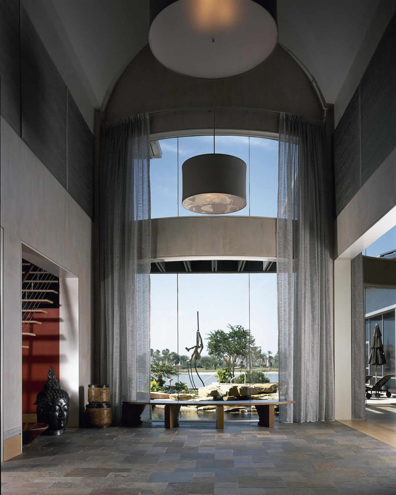 Imagen de recibidores y pasillos minimalistas extra grandes con paredes grises y suelo de pizarra