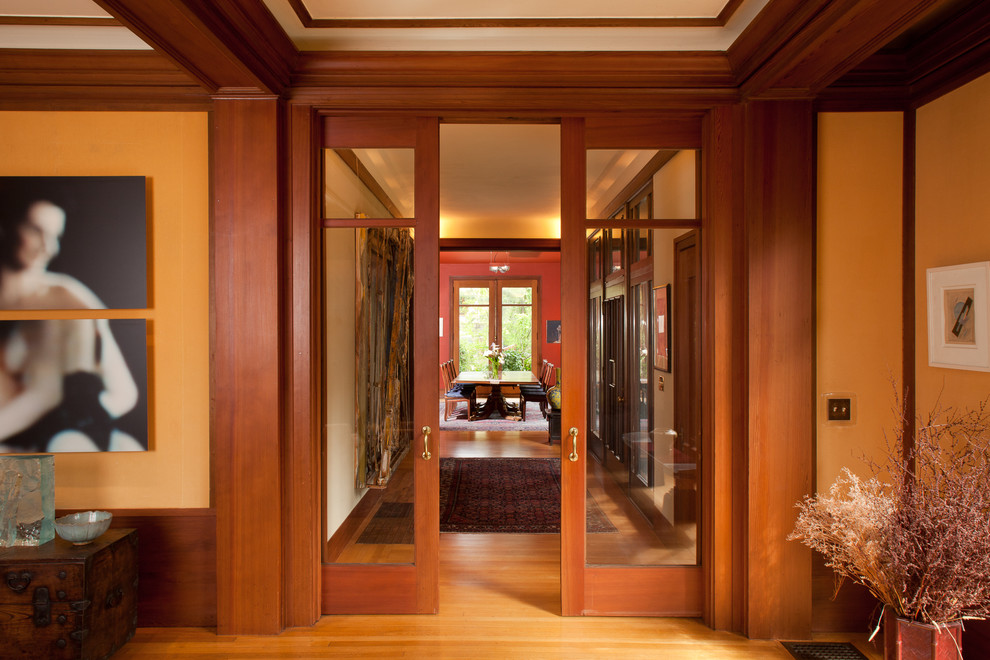 Cette photo montre un couloir craftsman avec un sol en bois brun.
