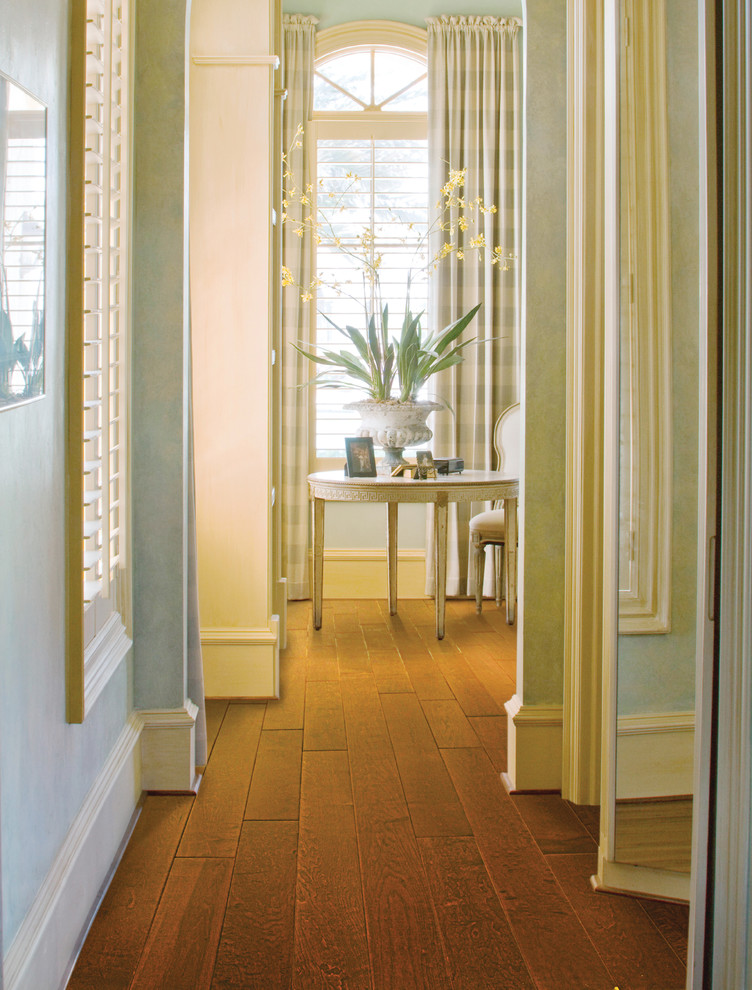 Esempio di un ingresso o corridoio minimal di medie dimensioni con pareti verdi e pavimento in legno massello medio
