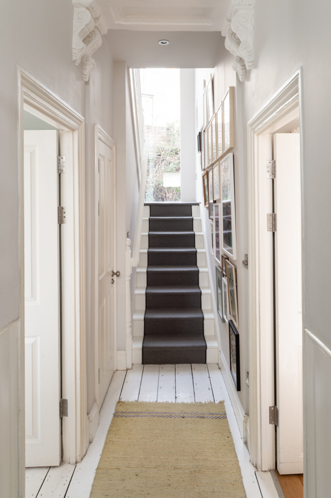 Стильный дизайн: коридор среднего размера в скандинавском стиле с серыми стенами, деревянным полом и белым полом - последний тренд