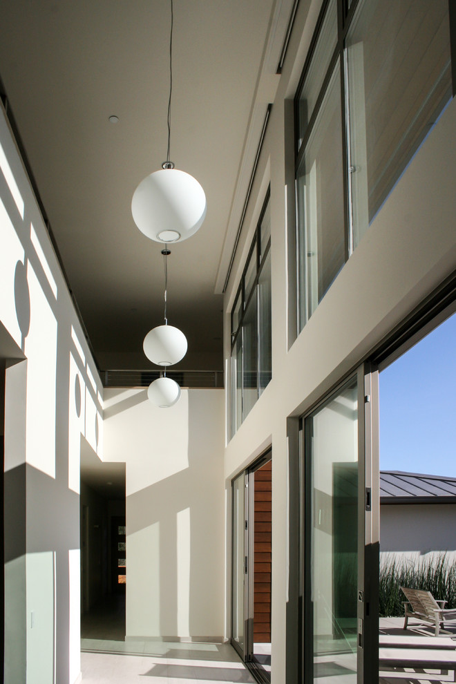 Immagine di un ingresso o corridoio minimal di medie dimensioni con pareti bianche e pavimento in gres porcellanato