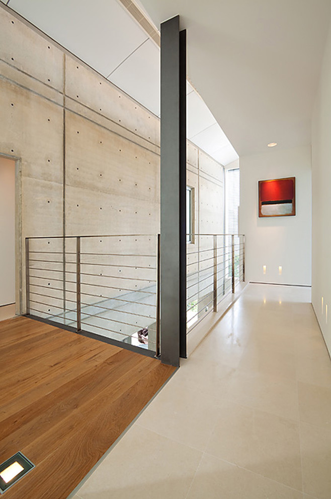 Idées déco pour un couloir moderne avec un mur blanc et un sol en bois brun.