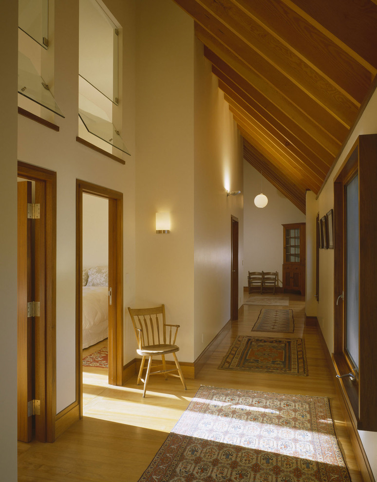 Minimalist medium tone wood floor hallway photo in Other with beige walls