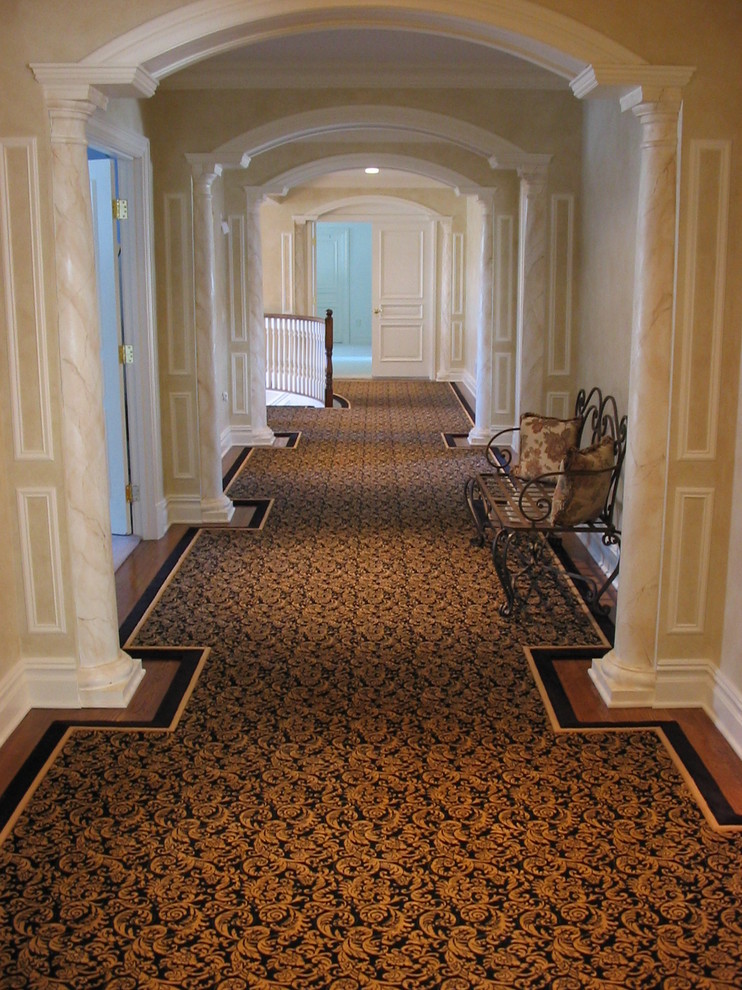 Inspiration pour un couloir traditionnel de taille moyenne avec un sol en bois brun et un mur beige.