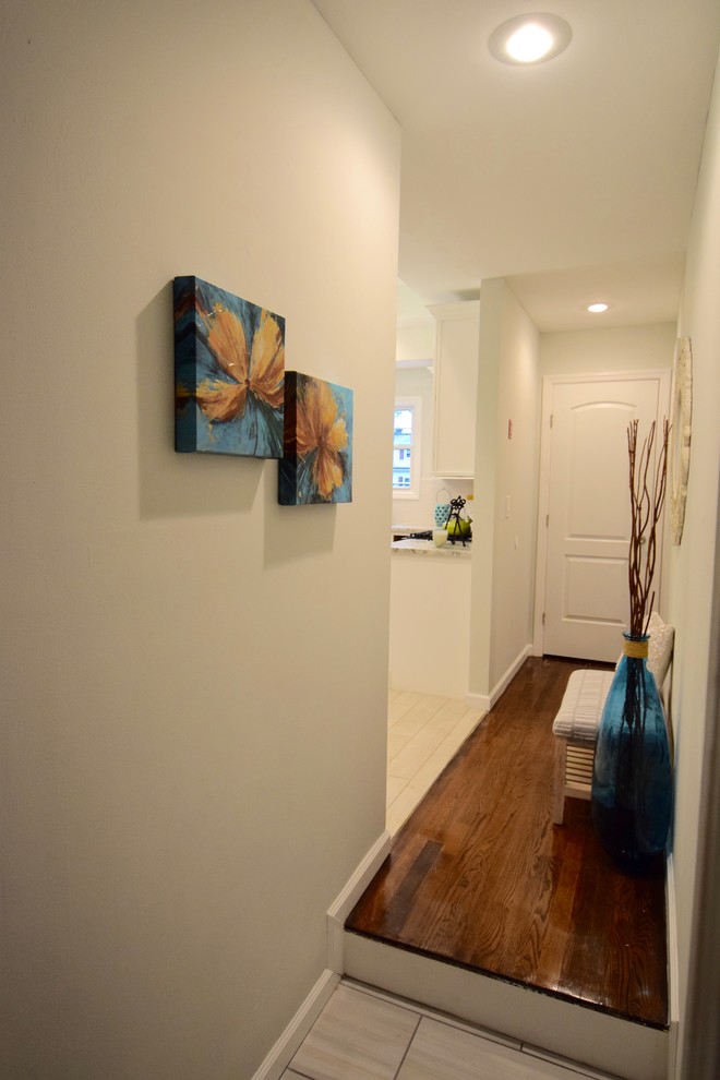Cette image montre un petit couloir traditionnel avec un mur beige et parquet foncé.