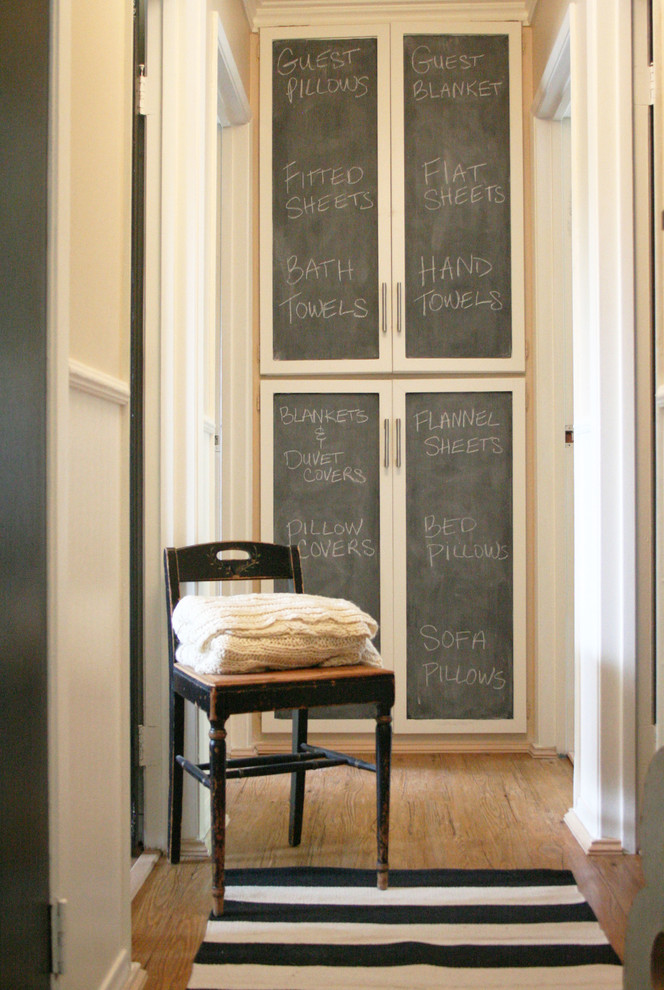 Mid-sized elegant medium tone wood floor hallway photo in Los Angeles with beige walls