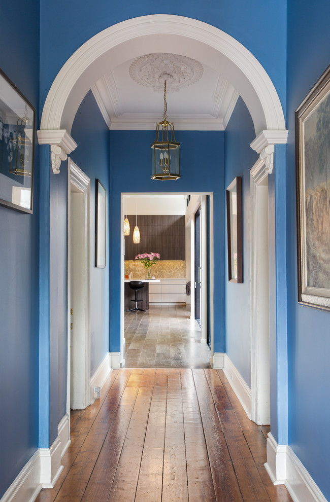 Idéer för att renovera en mellanstor vintage hall, med blå väggar, mellanmörkt trägolv och brunt golv