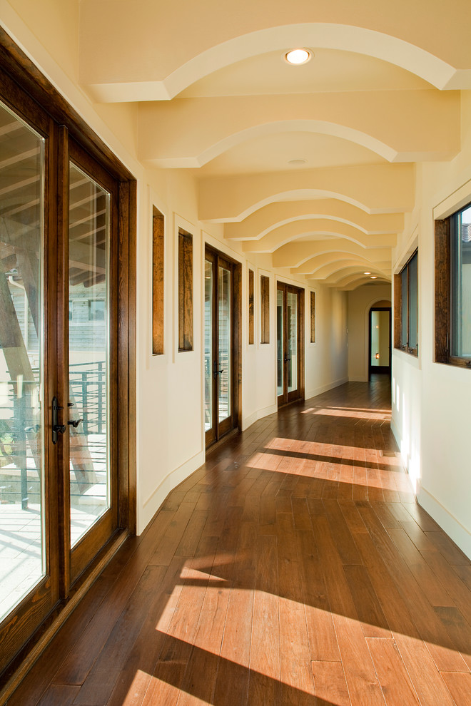 На фото: коридор в средиземноморском стиле с бежевыми стенами, паркетным полом среднего тона и оранжевым полом