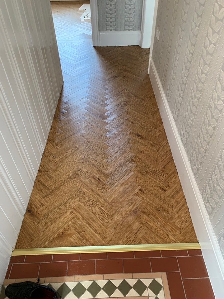 Hallway - mid-sized contemporary vinyl floor and brown floor hallway idea in Manchester with white walls