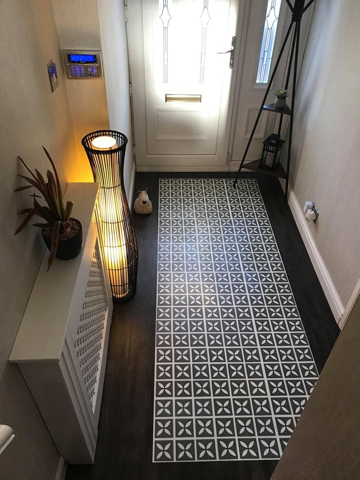 Cette image montre un couloir design de taille moyenne avec un mur beige, un sol en vinyl et un sol noir.