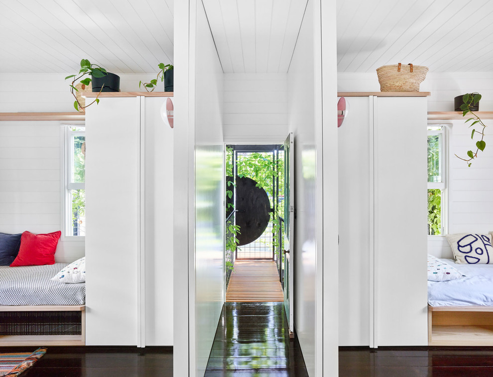 Moderner Flur mit weißer Wandfarbe, dunklem Holzboden und schwarzem Boden in Brisbane
