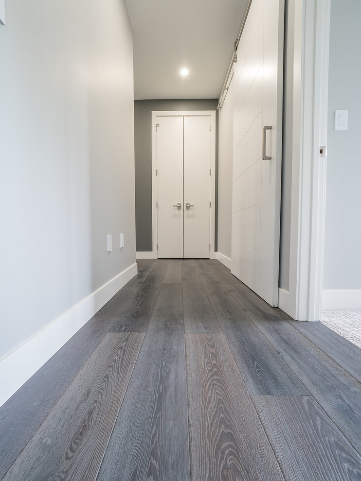 Mittelgroßer Moderner Flur mit grauer Wandfarbe, braunem Holzboden und grauem Boden in Edmonton