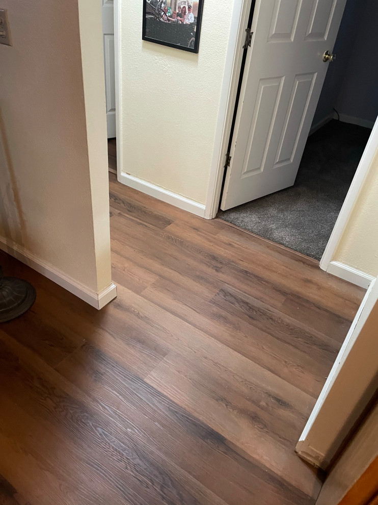 Inspiration for a mid-sized vinyl floor and brown floor hallway remodel in Sacramento with white walls