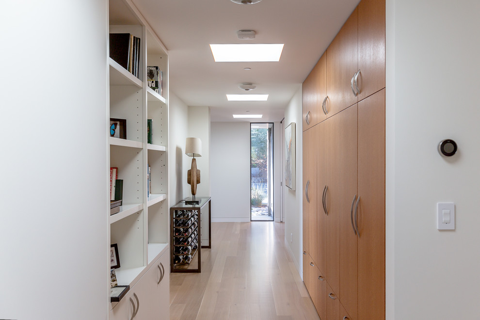 На фото: большой коридор: освещение в стиле модернизм с белыми стенами, светлым паркетным полом и бежевым полом