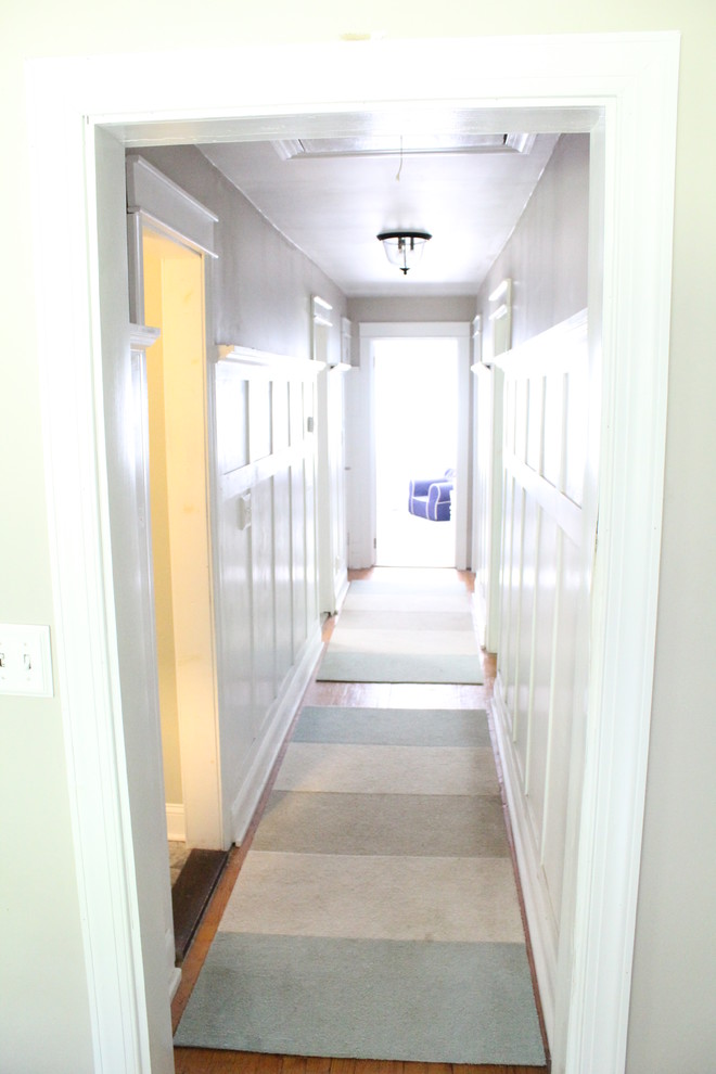 Hallway - mid-sized traditional light wood floor hallway idea in New York with gray walls