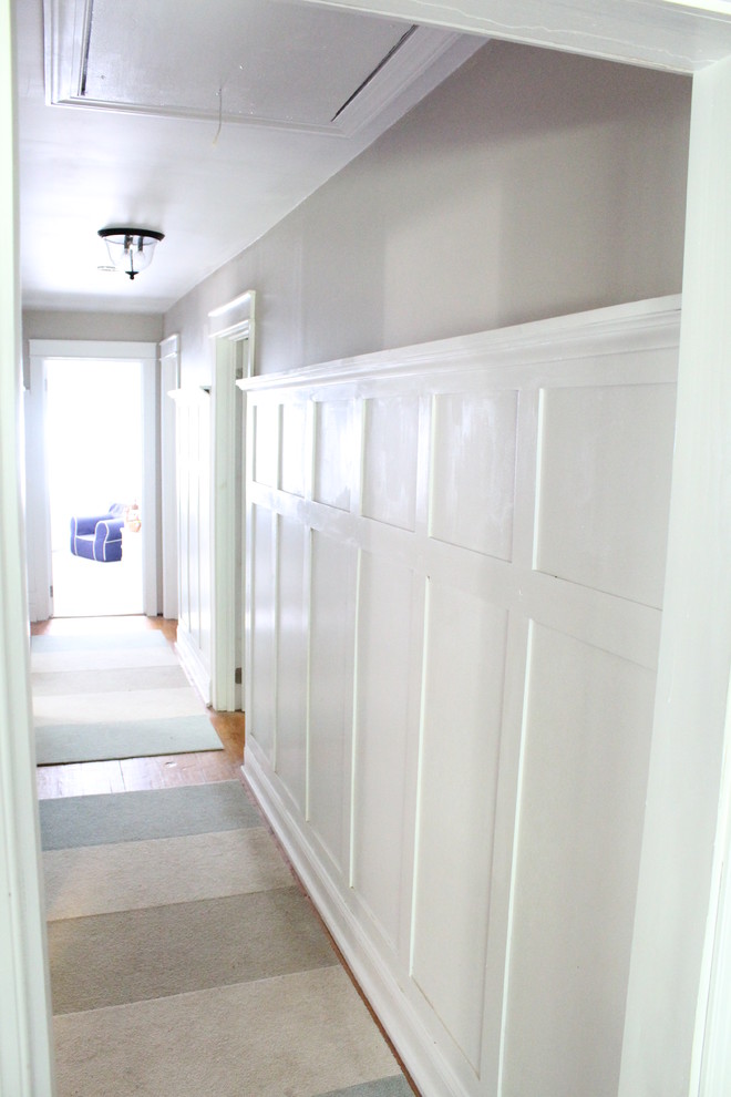 Inspiration pour un couloir traditionnel de taille moyenne avec un mur gris et parquet clair.