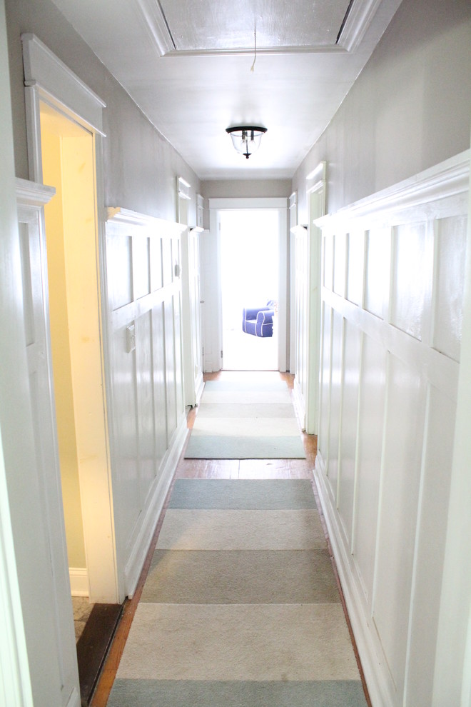 Réalisation d'un couloir tradition de taille moyenne avec un mur gris et parquet clair.
