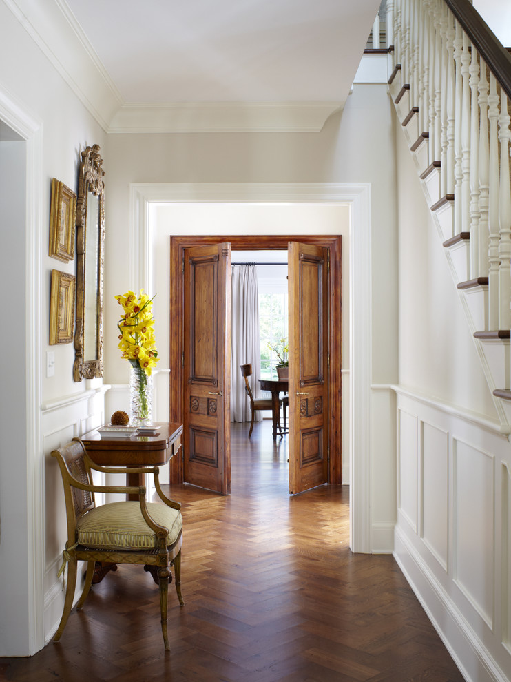 Ispirazione per un ingresso o corridoio tradizionale con pareti bianche e pavimento in legno massello medio