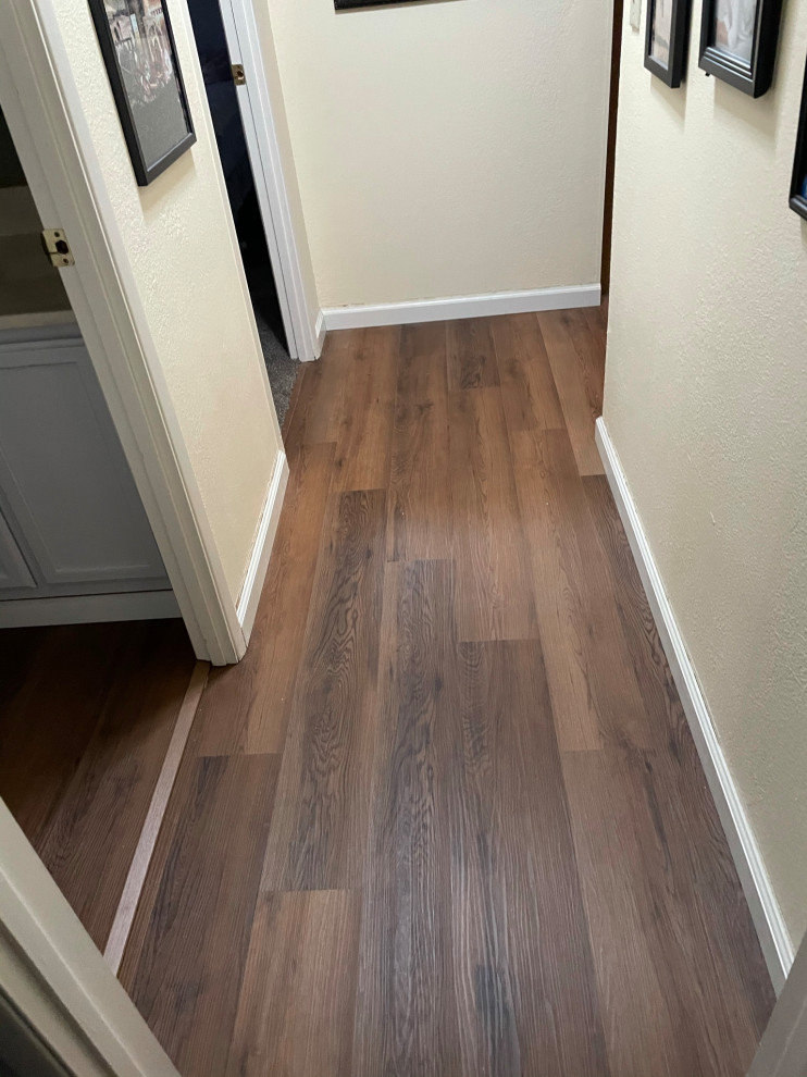 Example of a mid-sized vinyl floor and brown floor hallway design in Sacramento with white walls