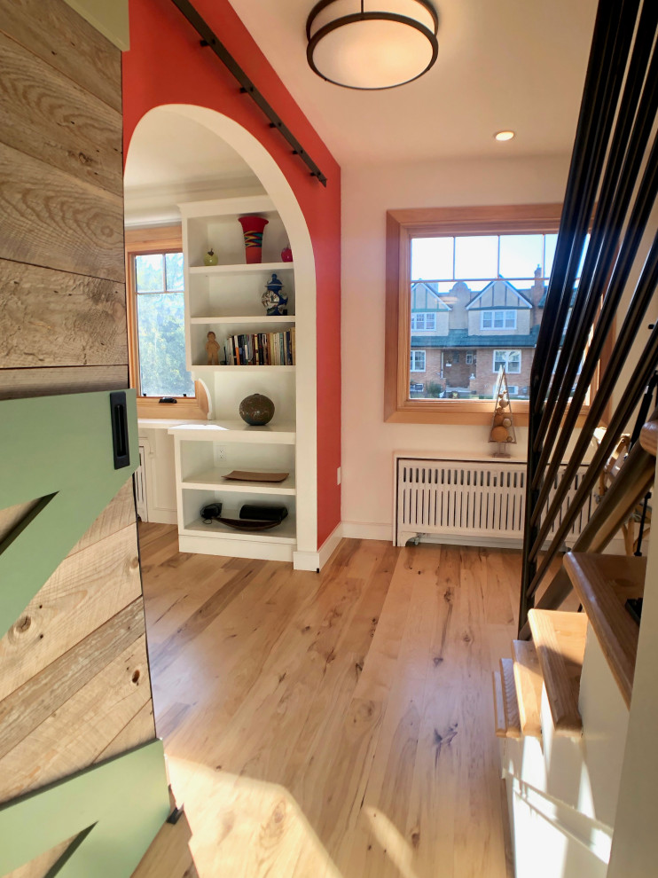 Großer Klassischer Flur mit bunten Wänden, hellem Holzboden, braunem Boden und gewölbter Decke in New York
