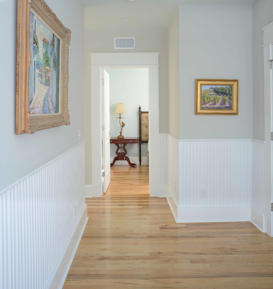 Immagine di un piccolo ingresso o corridoio chic con pareti grigie e pavimento in legno massello medio