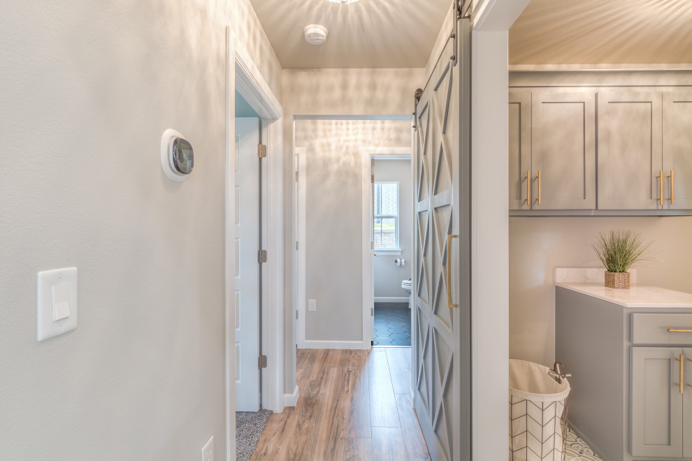 Farmhouse laminate floor and brown floor hallway photo in Other with gray walls