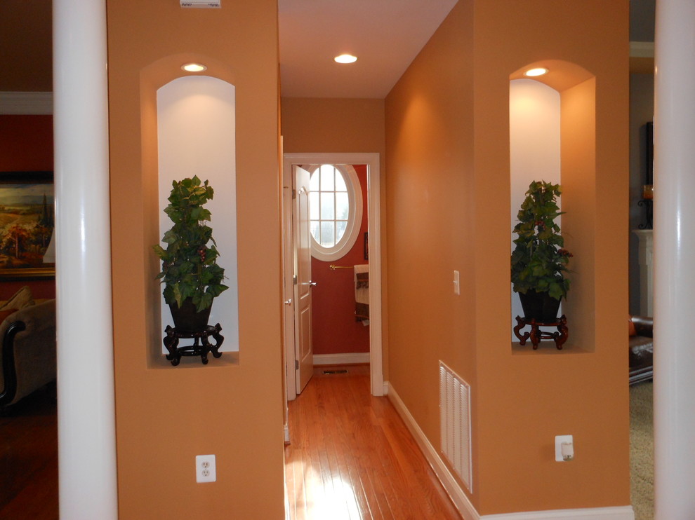На фото: коридор среднего размера в классическом стиле с оранжевыми стенами, паркетным полом среднего тона и оранжевым полом