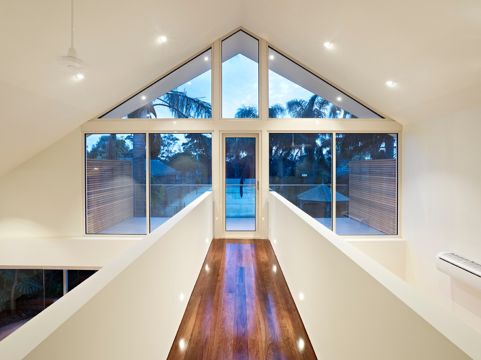 Moderner Flur mit weißer Wandfarbe und braunem Holzboden in Melbourne