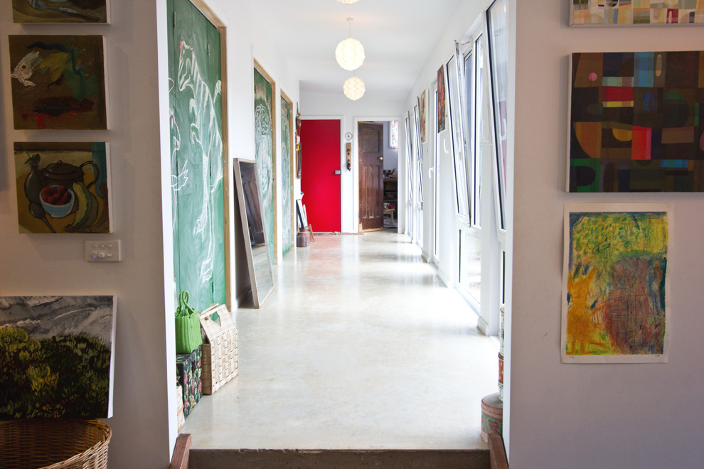 Foto di un ingresso o corridoio boho chic di medie dimensioni con pareti bianche, pavimento in cemento e pavimento bianco