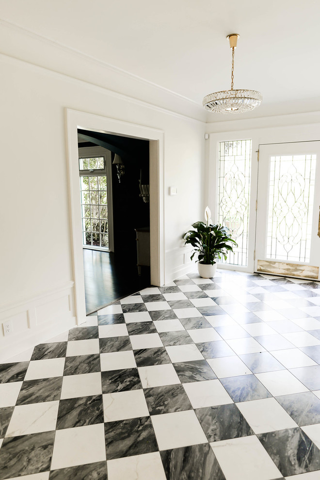 Стильный дизайн: большой коридор в классическом стиле с белыми стенами, мраморным полом и разноцветным полом - последний тренд