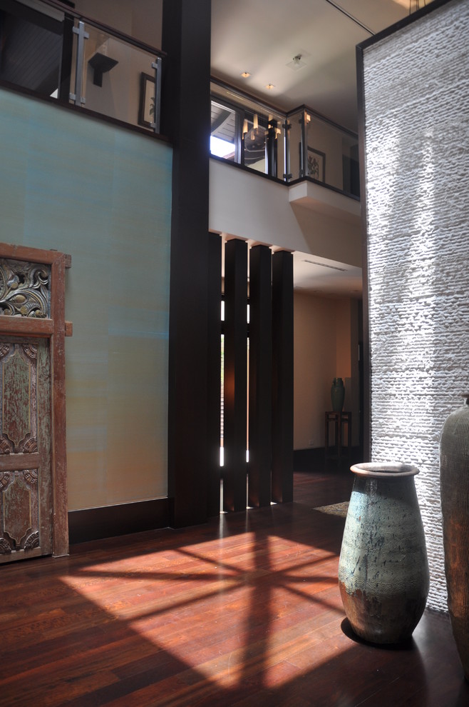 Example of a mid-sized asian medium tone wood floor and brown floor hallway design in Miami with multicolored walls